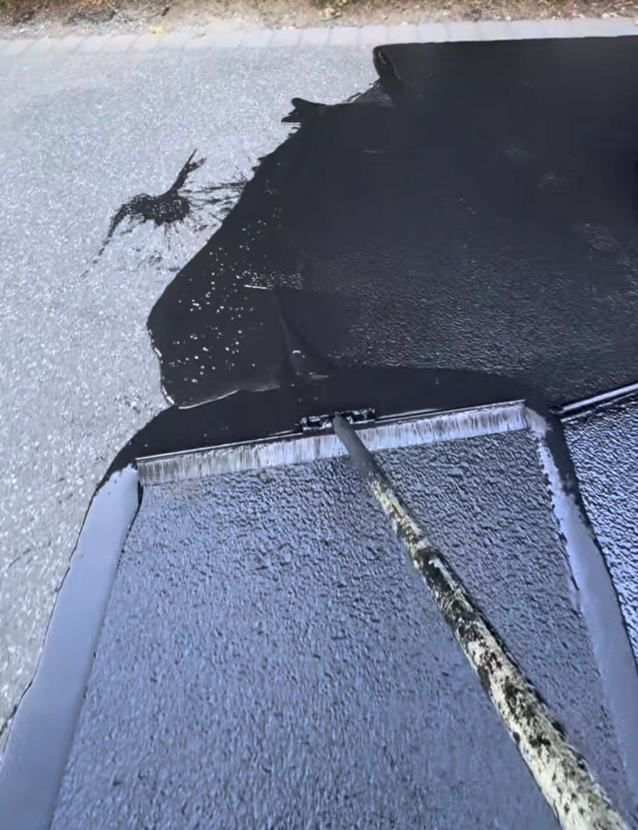 Close view of asphalt repair and seal coat application